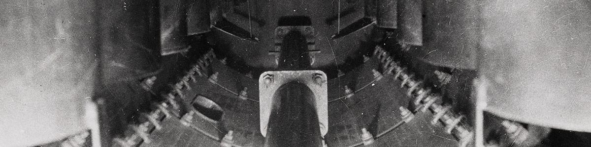 Photograph of the interior of a battleship showing 2 rows of torpedo tubes